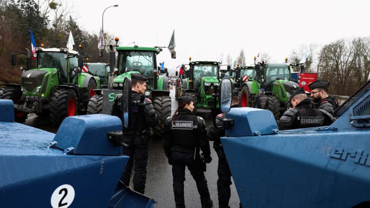 Gendarmes franceses y sus blindados controlan un grupo ed agricultores con tractores