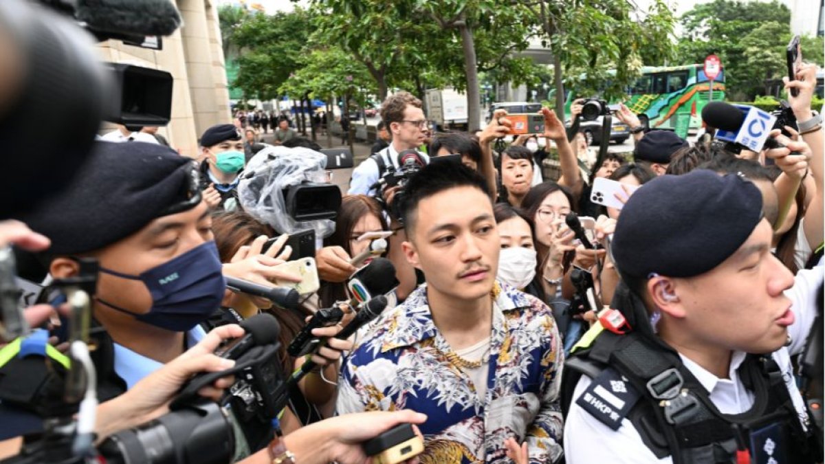 El ex concejal de distrito Shun Lee (C) es visto rodeado de policías y personal de los medios de comunicación a su salida tras ser declarado inocente en el Tribunal de Magistrados de West Kowloon, en Hong Kong, el 30 de mayo de 2024. Un tribunal de Hong Kong declaró a 14 personas culpables de subversión el 30 de mayo, al comienzo de la vista del veredicto en el mayor caso contra el bloque prodemocrático de la ciudad desde que China impuso una ley de seguridad nacional para aplastar la disidencia.