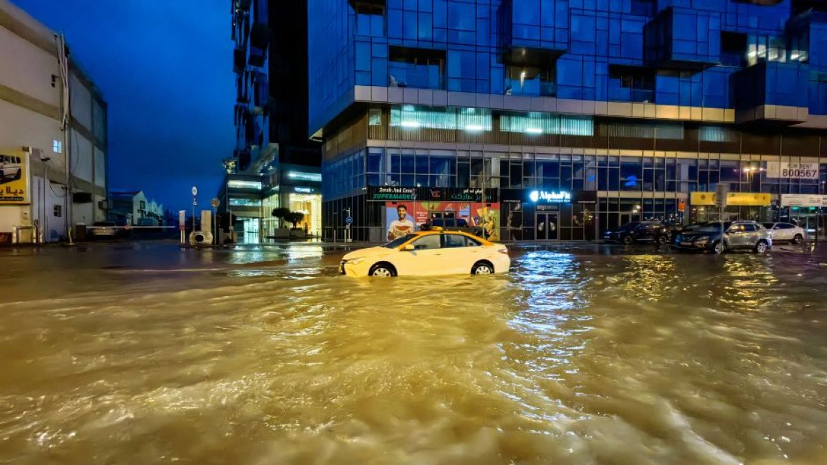 Un taxi circula por una calle inundada tras las fuertes lluvias caídas en Dubai la madrugada del 17 de abril de 2024. Dubai, el centro financiero de Oriente Medio, ha quedado paralizado por las lluvias torrenciales que provocaron inundaciones en los EAU y Bahréin y dejaron 18 muertos en Omán los días 14 y 15 de abril.
