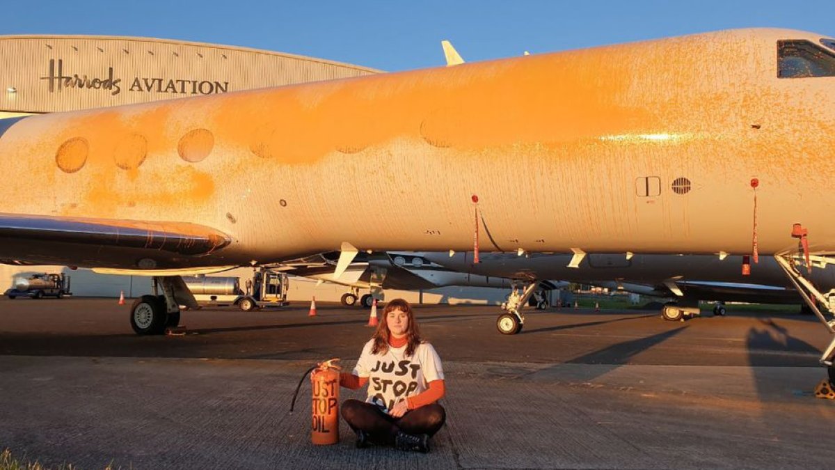 Imagen de Just Stop Oil donde se muestra a uno de los activistas con el avión de Taylor Swift vandalizado en protesta a las leyes climáticas de Reino Unido.