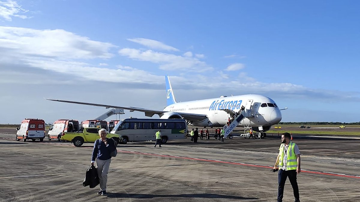 This UGC picture taken on July 1, 2024 and released as a courtesy by passenger Claudio Fernandez Arbes shows an Air Europa Boeing 787-9 Dreamliner sitting on the tarmac in Natal, in northeastern Brazil, on July 1, 2024, after making an emergency landing after encountering strong turbulence on its route from Madrid to Montevideo. - At least seven people were injured Monday during the flight prompting an emergency landing in Brazil, the airline said. The plane, with 325 people on board, was diverted in the early morning hours to the airport of Natal in northeastern Brazil on its way to the Uruguayan capital, the Spanish company said. (Photo by Claudio FERNANDEZ ARBES / UGC / AFP) / RESTRICTED TO EDITORIAL USE  MANDATORY CREDIT «  AFP PHOTO / UGC / COURTESY OF PASSENGER CLAUDIO FERNANDEZ ARBES» - NO MARKETING NO ADVERTISING CAMPAIGNS  DISTRIBUTED AS A SERVICE TO CLIENTS