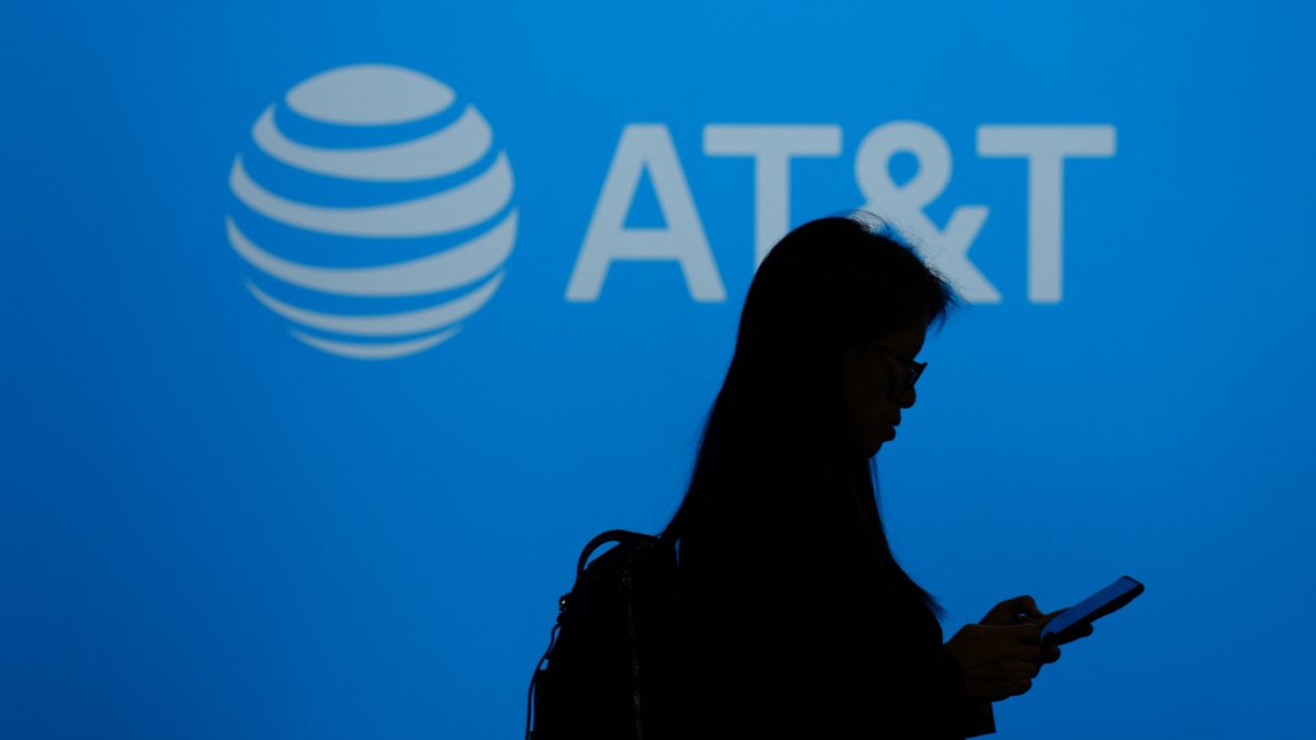 Un visitante pasa junto al logotipo de la multinacional estadounidense de telecomunicaciones AT&T durante el Mobile World Congress (MWC), el mayor encuentro anual de la industria de las telecomunicaciones, en Barcelona el 26 de febrero de 2024.