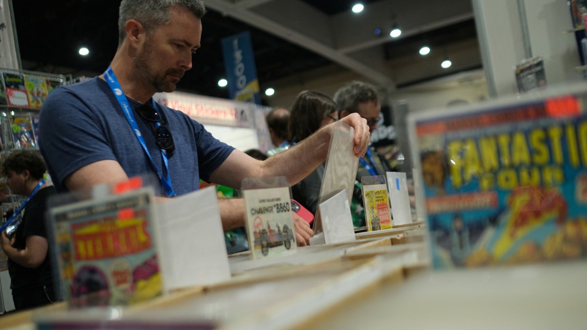 A person browses comic books on the first day of Comic-Con International at the San Diego Convention Center in San Diego, California, on July 24, 2024. (Photo by Chris DELMAS / AFP)