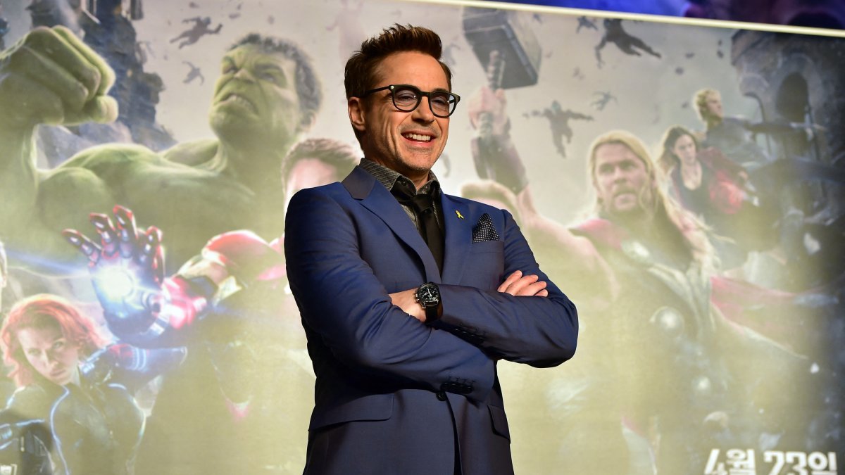 Robert Downey Jr. posa frente a un cartel publicitario de Los Vengadores.