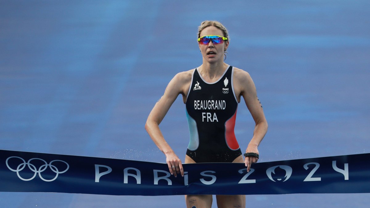 31 July 2024, France, Paris: Olympic Games, Paris 2024, triathlon, Olympic distance (1.5 km swim, 40 km bike, 10 km run), Cassandre Beaugrand from France crosses the finish line as the winner. Photo: Jan Woitas/dpa