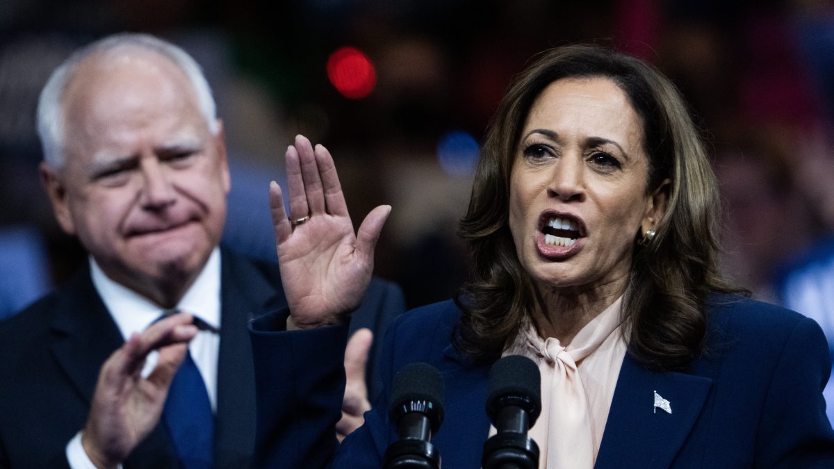 Kamala habla en primer término mientras Tim Walz aplaude en segundo plano durante el mítin de presentación del gobernador de Minesota como candidato a VP.