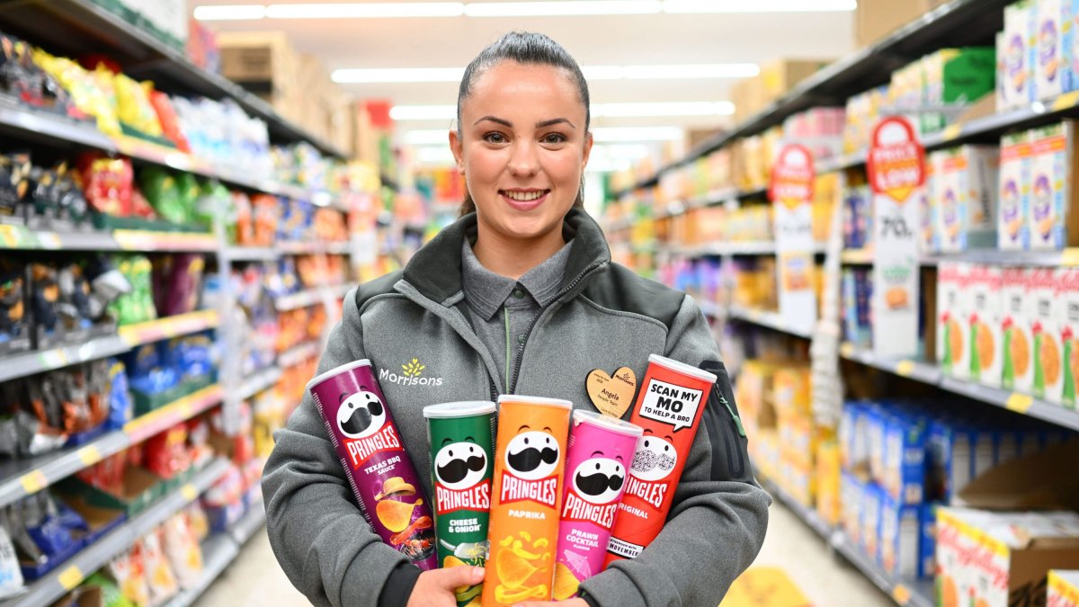 EDITORIAL USE ONLY Team member at Morrisons Stratford, Angela holds tubs of Pringles as the supermarket launches a new deal on the crisps for More Card holders. Issue date: Wednesday September 12, 2023.