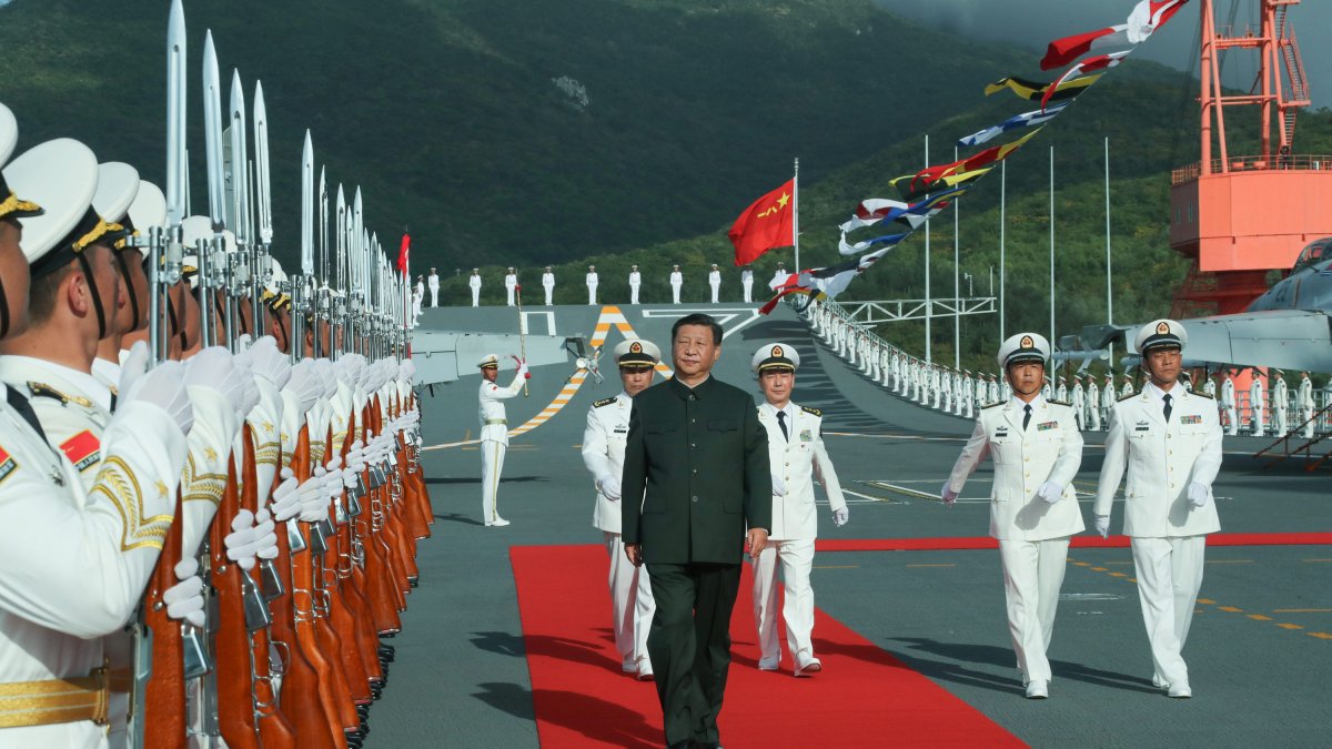 Xi Jinping aborda el portaaviones Shandong y pasa revista a la guardia de honor en un puerto naval en Sanya, provincia de Hainan, en el sur de China, el 17 de diciembre de 2019.