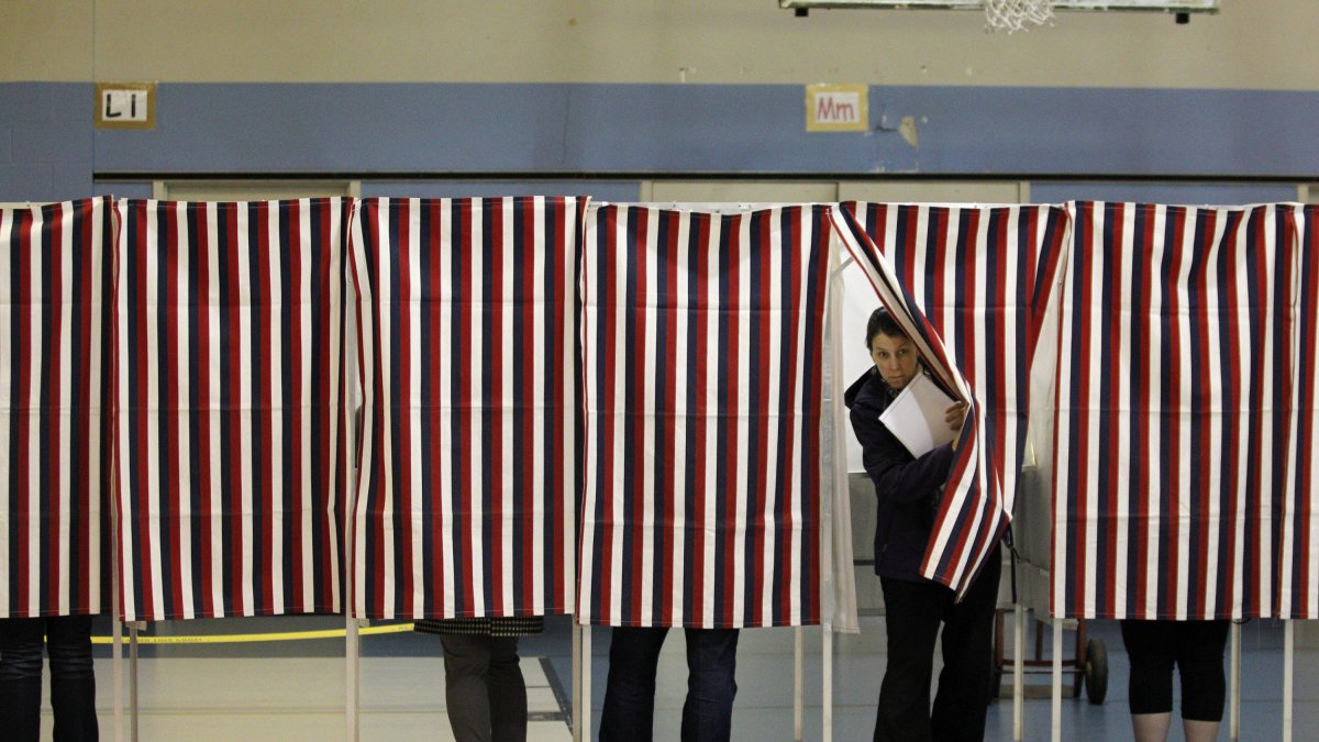 Una votante de New Hampshire sale de una cabina electoral después de rellenar su papeleta para las elecciones de mitad de mandato en el interior del Centro Juvenil Obispo Leo E. Oneil en Manchester, New Hampshire, el 4 de noviembre de 2014.