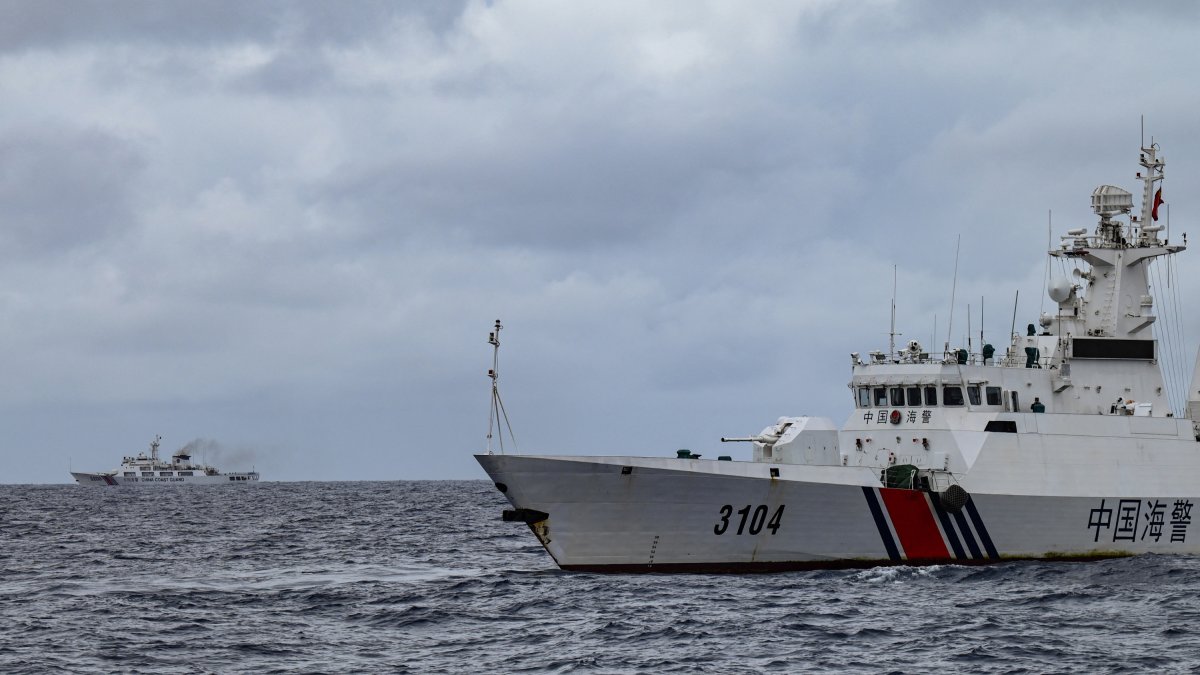 Buques de la Guardia Costera de China son vistos desde el buque de la Guardia Costera de Filipinas BRP Cabra durante una misión de suministro a Sabina Shoal en aguas disputadas del Mar de China Meridional el 26 de agosto de 2024.