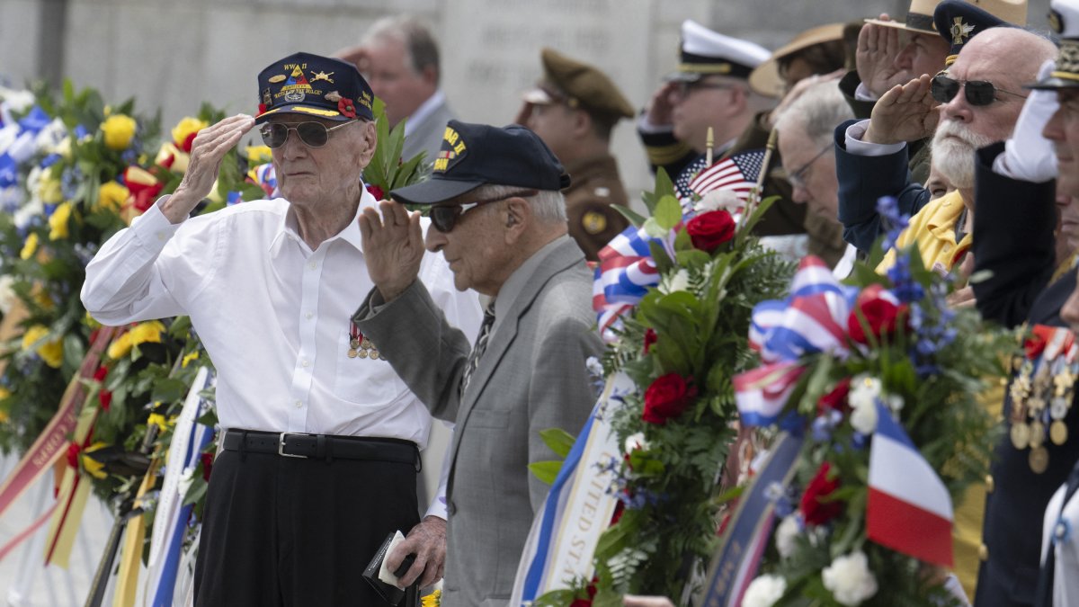 Los veteranos de la Segunda Guerra Mundial Harry Miller (izda.) y el coronel Frank Cohn (dcha.) saludan durante una ceremonia de colocación de coronas durante la celebración del Día de la Victoria en Europa en el Monumento Nacional de la Segunda Guerra Mundial en Washington, DC, el 8 de mayo de 2024.