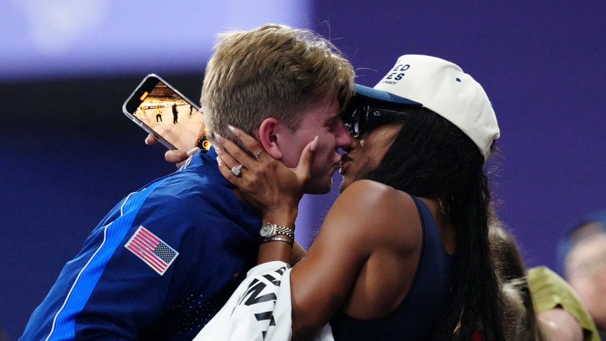 Gold medallist US' Hunter Woodhall (L) celebrates with his wife Olympic women's long jump champion Tara Davis-Woodhall after the victory ceremony for the Men's 400m T62 final event at the Stade de France in Saint-Denis, outside Paris on September 6, 2024. (Photo by Dimitar DILKOFF / AFP)