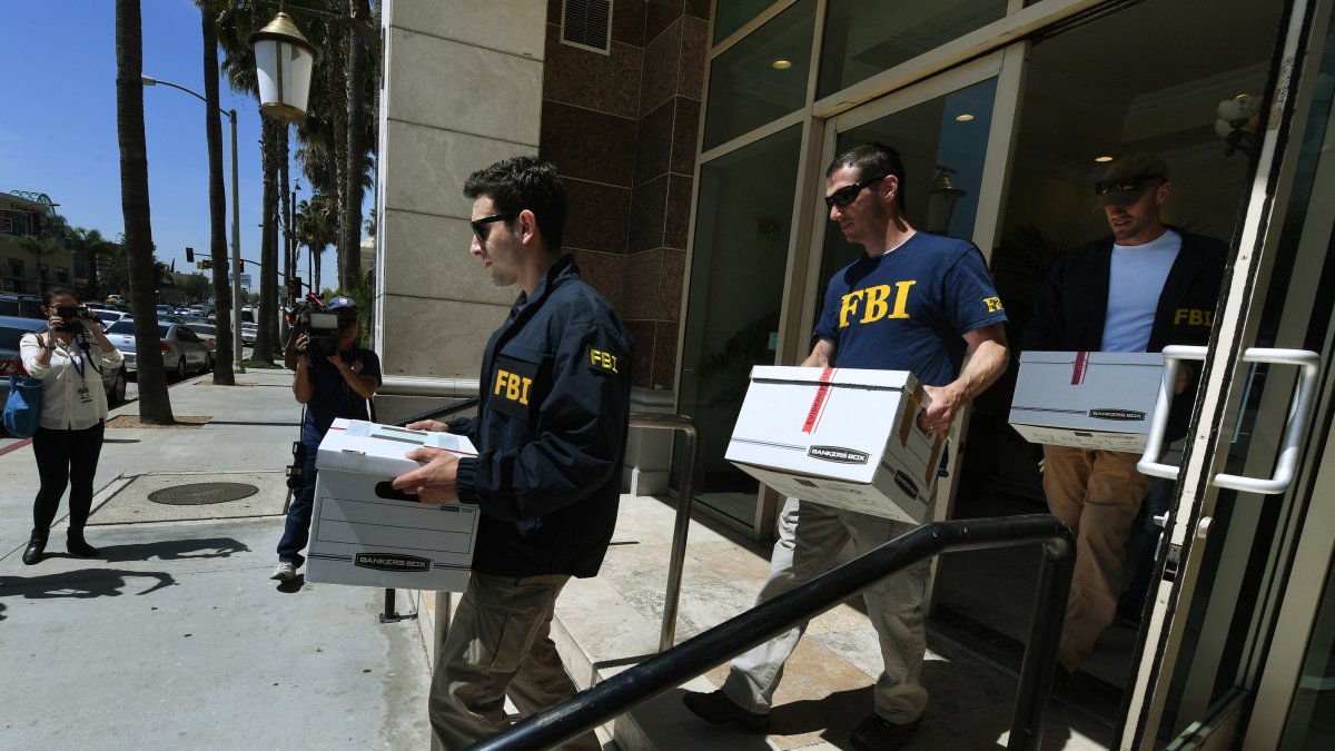 Agentes del FBI retiran cajas de documentos de las oficinas del California Investment Immigration Fund tras presentar órdenes de registro en el marco de una investigación sobre una presunta trama de fraude de visados de alta gama por valor de 50 millones de dólares en la que están implicados hasta 100 ciudadanos chinos en San Gabriel, California, el 5 de abril de 2017.