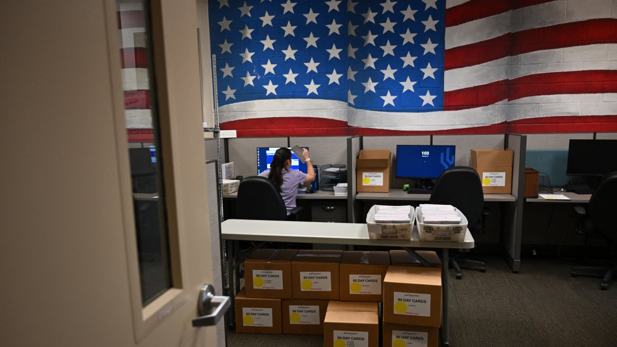 Un trabajador electoral procesa la información de los votantes en la Sala de Banderas del Centro de Tabulación y Elecciones del Condado de Maricopa (MCTEC) antes de las elecciones primarias y generales de Arizona de 2024 en Phoenix, Arizona, el 3 de junio de 2024.