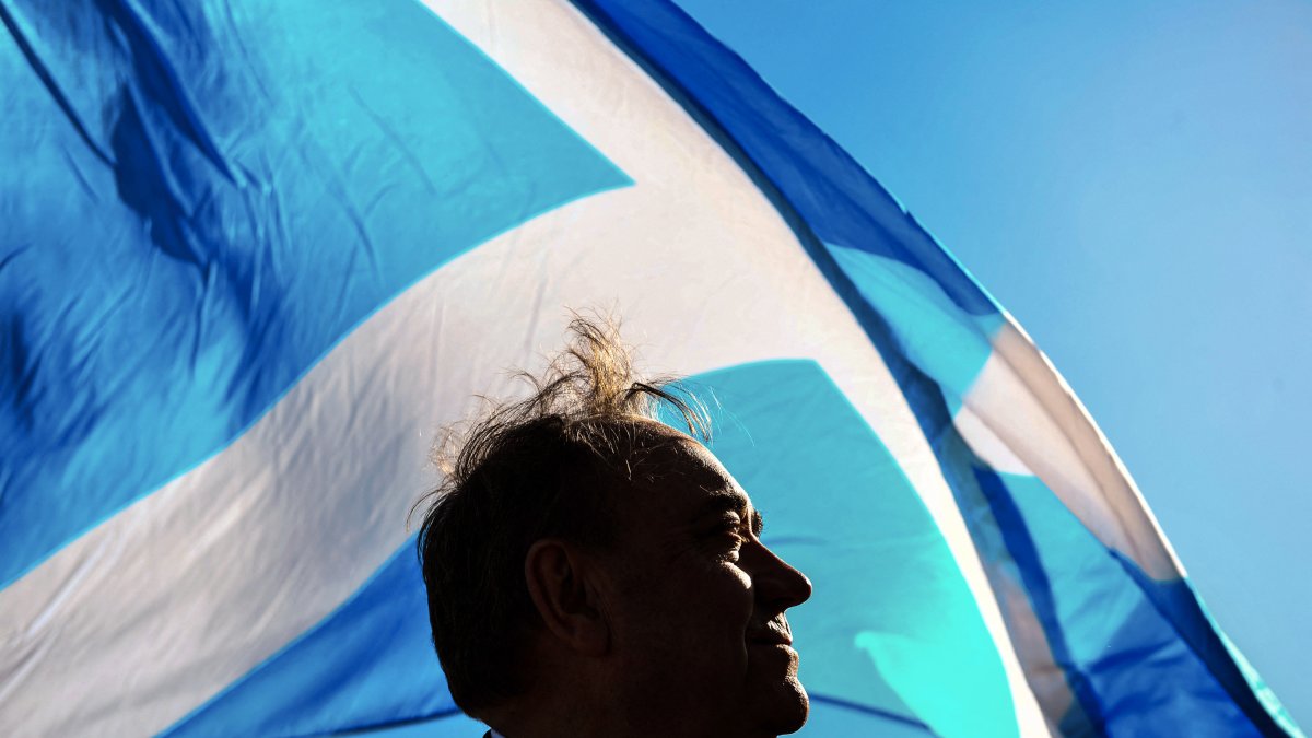 El exministro principal de Escocia Alex Salmond posa con una bandera nacional.