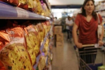 Mujer recorriendo supermercado con changuito