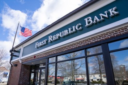 Sede del banco First Republic Bank vista desde afuera. Hay un cartel con el nombre del banco escrito en letras blancas sobre fondo verde. También puede verse una bandera norteamericana.