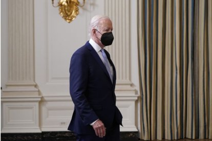 Joe Biden appears before the press wearing a face mask after passing the COVID