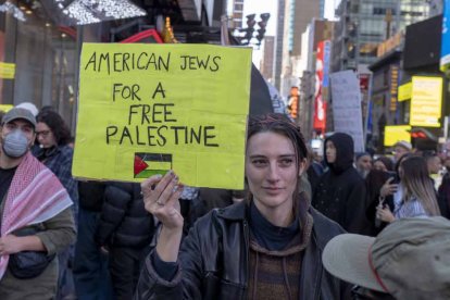 October 13, 2023, New York, United States: A woman holds a placard reading ''American Jews For A Free Palestine'' during a Palestinian Day of Action protest in Times Square, New York City. Across the country and around the world, people are holding rallies and vigils for both Palestinians and Israelis following a surprise attack by Hamas on October 7. The attack has resulted in a bombardment of Gaza by the Israeli military and a a possible ground invasion of the territory. (Credit Image: © Ron Adar/SOPA Images via ZUMA Press Wire)