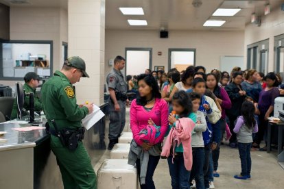 Several immigrants are assisted by members of the Border Patrol to enter the country.