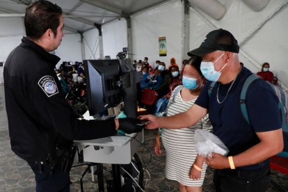 Migrantes entregando sus papeles a las autoridades fronterizas.