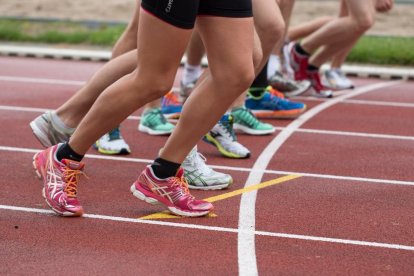 Varios atletas comienzan a correr en una carrera de atletismo.