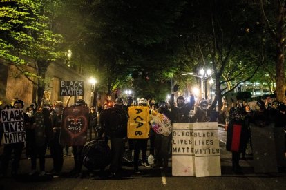 Alborotadores del Black Lives Matter portando pancartas contra la policía durante una manifestación.