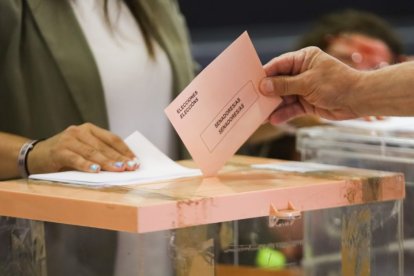 Mano metiendo un voto en una urna.