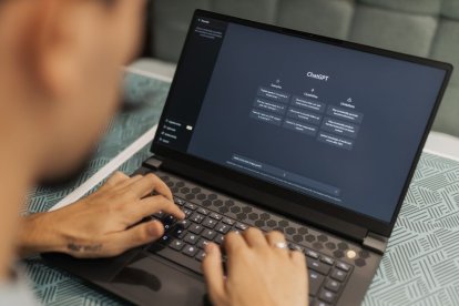 Hombre escribiendo en un portátil tareas a ChatGPT.