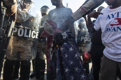 Une bandera de Estados Unidos arde durante una manifestación violenta en Haití.