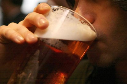 Un hombre tomando un vaso de cerveza.