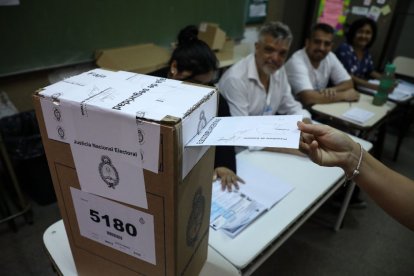 Imagen un votante introduciendo un voto dentro de una urna en el balotaje argentino.