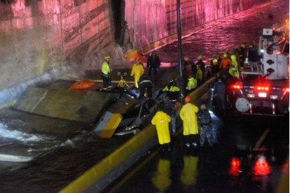 Rescuers search for people trapped under a wall that collapsed on several vehicles after heavy rains on 27 de Febrero Avenue in Santo Domingo on November 18, 2023 in República Dominicana.