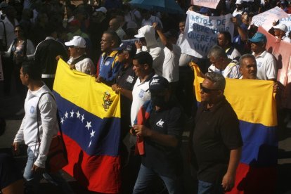 Venezolanos protestando en la calle con banderas del país en 2023.