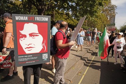 Cartel con una imagen de la cara de Mahsa Amini durante una protesta tras el asesinato de la joven iraní.