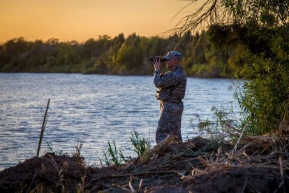 Un soldado de la Guardia Nacional de Texas patrulla el Río Grande, entre México y Estados Unidos, al atardecer.