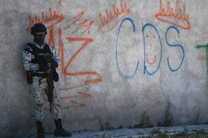 Un soldado mexicano monta guardia junto a unas pintadas del narcotraficante Mayo Zambada y del grupo criminal Cartel de Sinaloa.