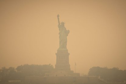 Imagen de la Estatua de la Libertad, en Nueva York, teñida de naranja a consecuencia de la nube tóxica proveniente de Canadá.