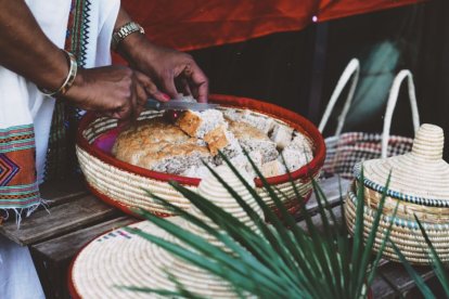 Imagen de una mujer en Etiopía partiendo pan que le han entregado asociaciones benéficas gracias a los programas de ayuda alimentaria.