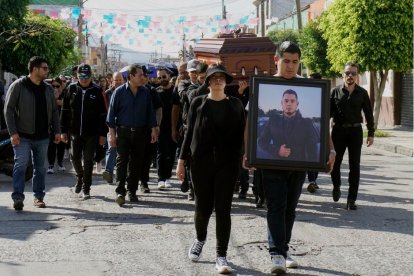 Varios hombres llevan el féretro de una de las 12 personas asesinadas en un rancho en una fiesta prenavideña por pistoleros el pasado 17 de diciembre