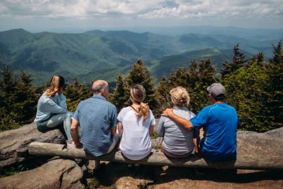 Familia descansando frente a una montaña.