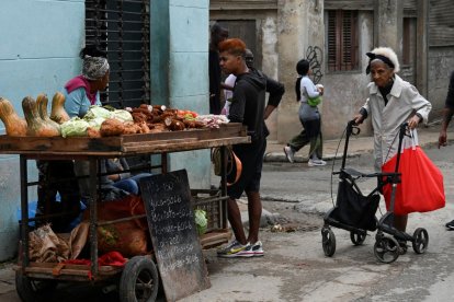 People buy food on a street in Havana