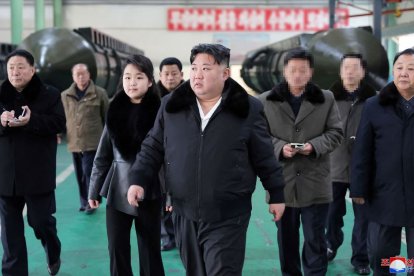 Imagen difundida por la Agencia Central de Noticias de Corea del Norte (KCNA) el 5 de enero de 2024 que muestra al líder norcoreano Kim Jong Un (C) inspeccionando una importante planta de producción de vehículos militares junto a su hija Ju Ae.