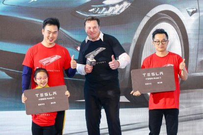 El consejero delegado de Tesla, Elon Musk (C), posa para las fotos con los compradores durante la ceremonia de entrega del Modelo 3 fabricado en China por Tesla en Shanghái.