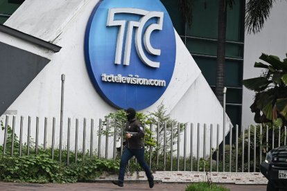 Un miembro de las fuerzas del orden ecuatorianas corre frente a la sede de Tc Televisión, donde hombres armados secuestraron a la plantilla del medio en un asalto coordinado contra la sociedad ecuatoriana.