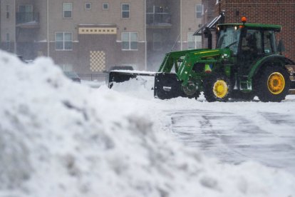 Un tractor quita la nieve de un estacionamiento en Ankeny, Iowa, el 12 de enero de 2024 | AFP