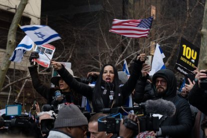 Imagen de archivo de una mujer ondeando banderas de Israel y de los Estados Unidos de América durante una concentración que exige la liberación de los rehenes israelíes secuestrados por Hamás en la plaza Dag Hammarskjold, frente a la sede de la ONU.