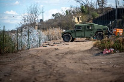 Miembros de la Guardia Nacional de Texas se sientan dentro de la valla en Shelby Park el 3 de febrero de 2024 en Eagle Pass, Texas.