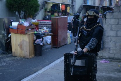 Un policía durante una redada en un barrio de Guayaquil, este 8 de mayo. (Foto por Gerardo MENOSCAL / AFP)