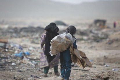 Niñas afganas llevan su bolsa, que está llena de artículos utilizables en un sitio de basura en Kabul, Afganistán, el 5 de junio de 2012, el Día Mundial del Medio Ambiente.